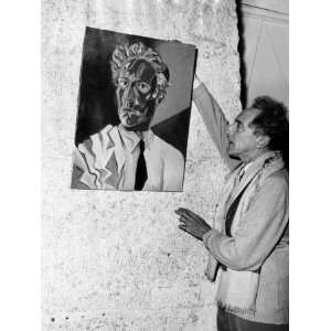  Jean Cocteau Adjusts His Self Portrait at an Exhibition in 