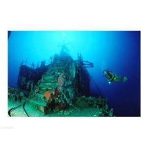  Scuba diver watching a shipwreck underwater Poster (24.00 