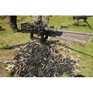  A .50 Caliber Browning Machine Gun with a pile of spent 